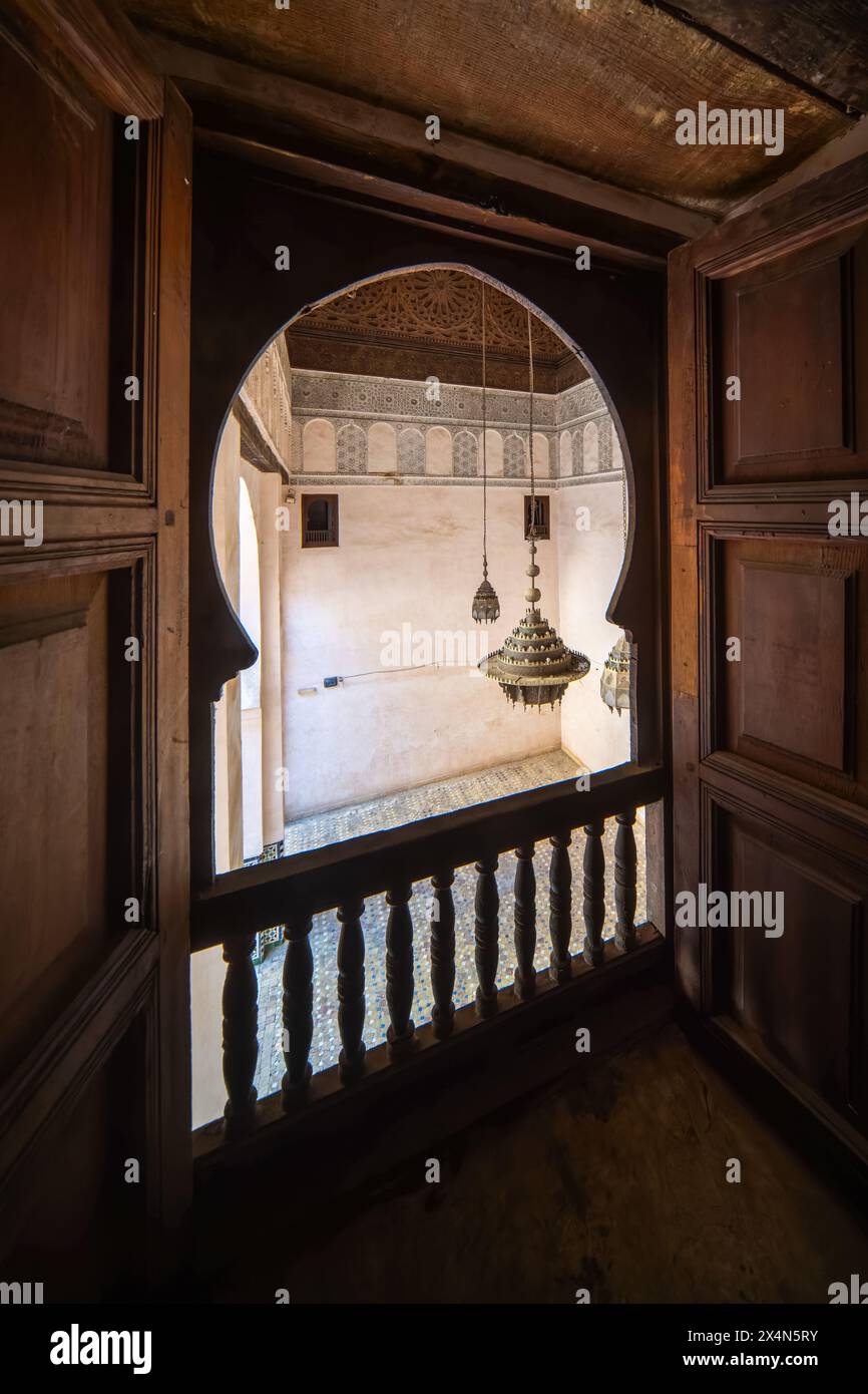 Ein ruhiger Blick fängt das Wesen von Fès durch das verzierte Fenster von Cherratine Madrasa ein. Fès, Marokko. Stockfoto