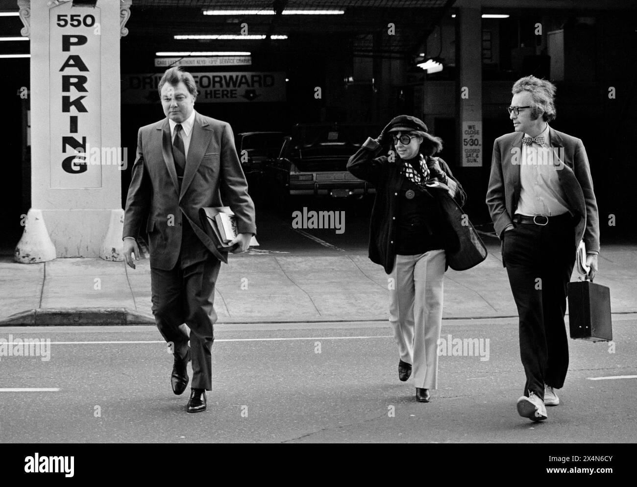 Dr. Louis J. West, left, psychiatrist for the defense, crosses the street and heads for San Francisco's Federal Building on Feb. 25, 1976, where he was scheduled to return to the witness stand in the Patty Hearst bank robbery trial. The day before, Dr. West told jurors that Miss Hearst was fighting for survival in captivity and adopted "alternate personalities". (AP Photo/Sal Veder) Stockfoto