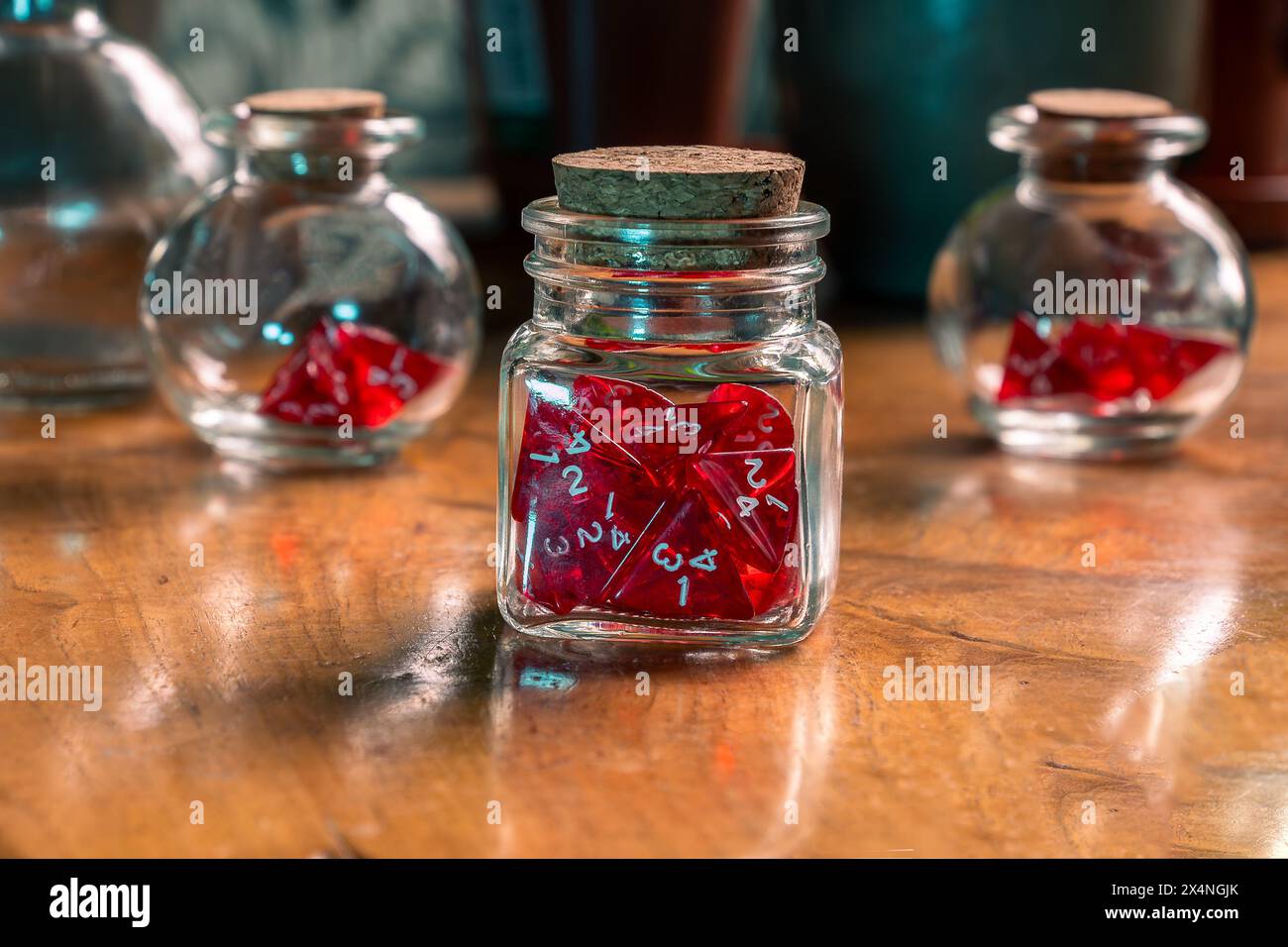 Rote Würfel in Glasgläsern auf einem Vintage-Holztisch, die Spielcharme mit rustikaler Eleganz verbinden Stockfoto