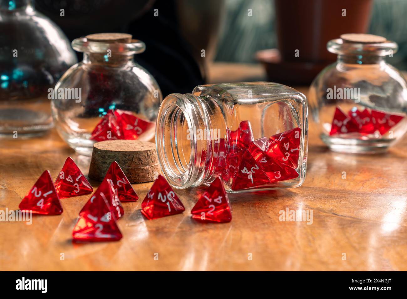 Rote Würfel aus einem Glasgefäß auf einem rustikalen Holztisch, die einen Moment des Glücks in eleganter Unordnung festhalten Stockfoto