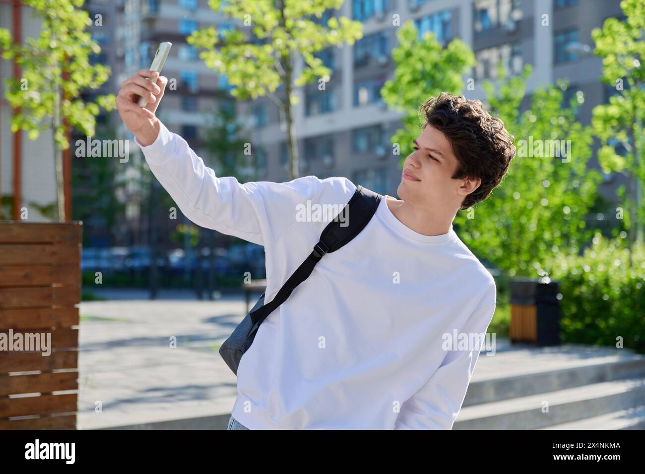 Junger Schüler mit Smartphone in der Hand, der ein Selfie-Porträt macht Stockfoto
