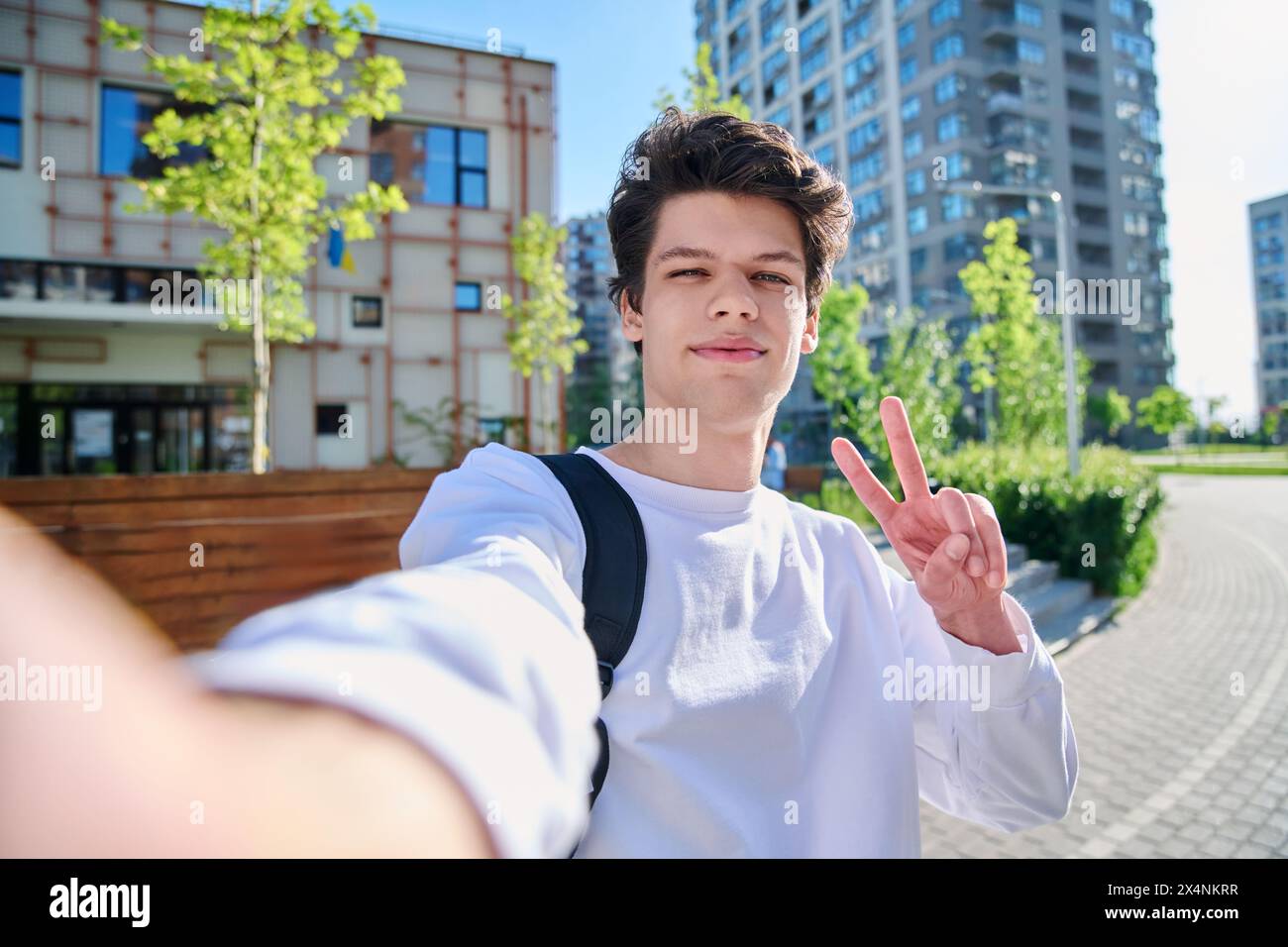 Selfie-Porträt eines jungen gutaussehenden Mannes mit lockigen Haaren, draußen Stockfoto