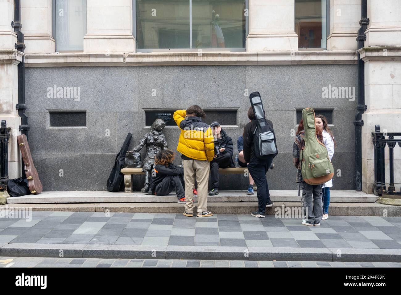 Sechs junge Musiker halten an Tommy Steel Statue von Eleanor Rigby Stockfoto