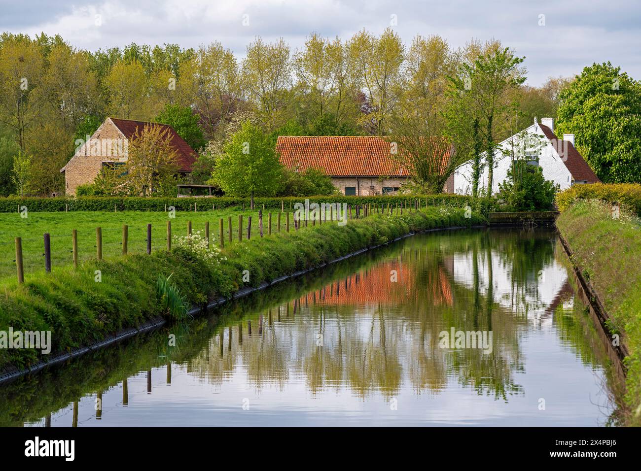 Traditionelle ländliche flämische Architektur mit Kanal, Stadt Moere, Region Brügge, Flandern, Belgien. Stockfoto