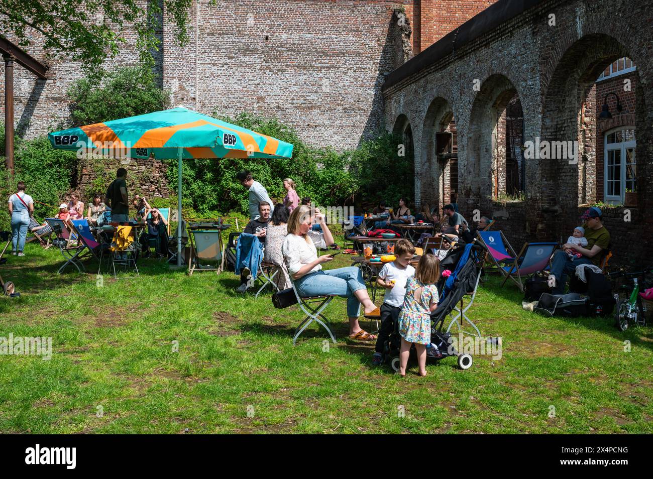 Region Brüssel Hauptstadt, Belgien - 1. Mai 2024 - das Museum La Fonderie über die Geschichte der lokalen Industrie. Familien picknicken am Labor Day EV Stockfoto