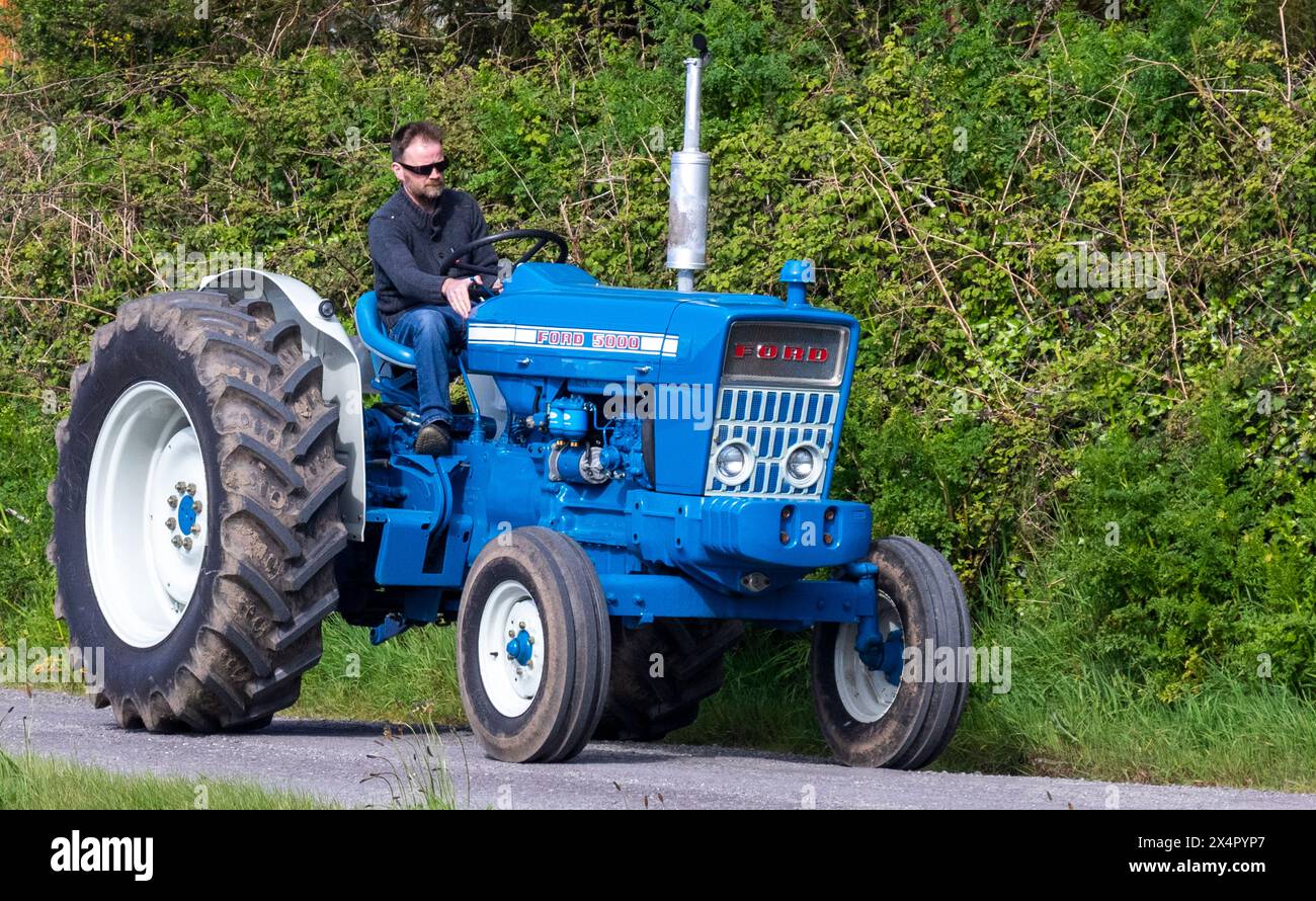 Mann, der einen Ford 5000-Traktor fährt Stockfoto