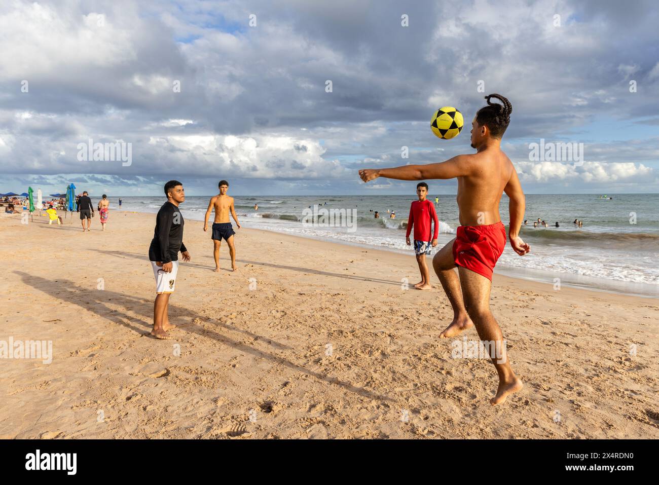 Männer spielen Fußball am Itacimirim Beach, Praia de Itacimirim, Salvador, Bahia, Brasilien Stockfoto