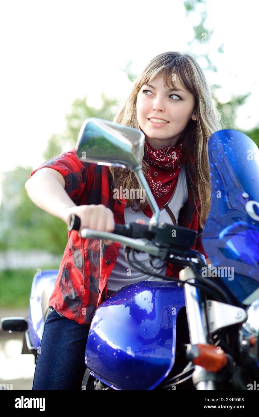 Beauty blondes Teenager Mädchen fährt blaues Motorrad Stockfoto