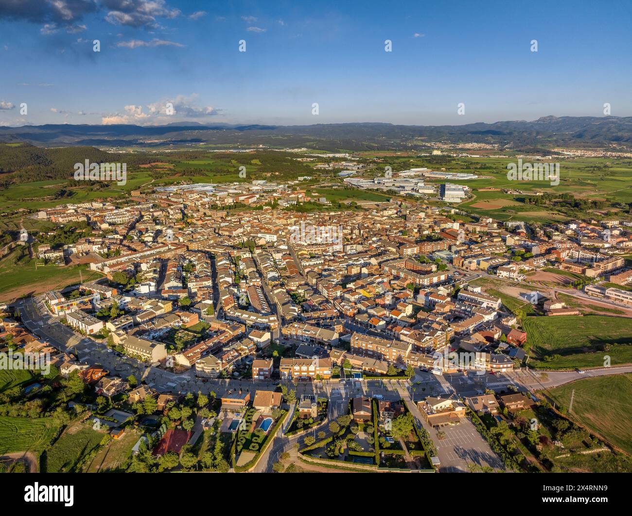 Aus der Vogelperspektive der Stadt Santpedor und der grünen Felder von Pla de Bages bei Sonnenuntergang im Frühling (Barcelona, ​​Catalonia, Spanien) Stockfoto