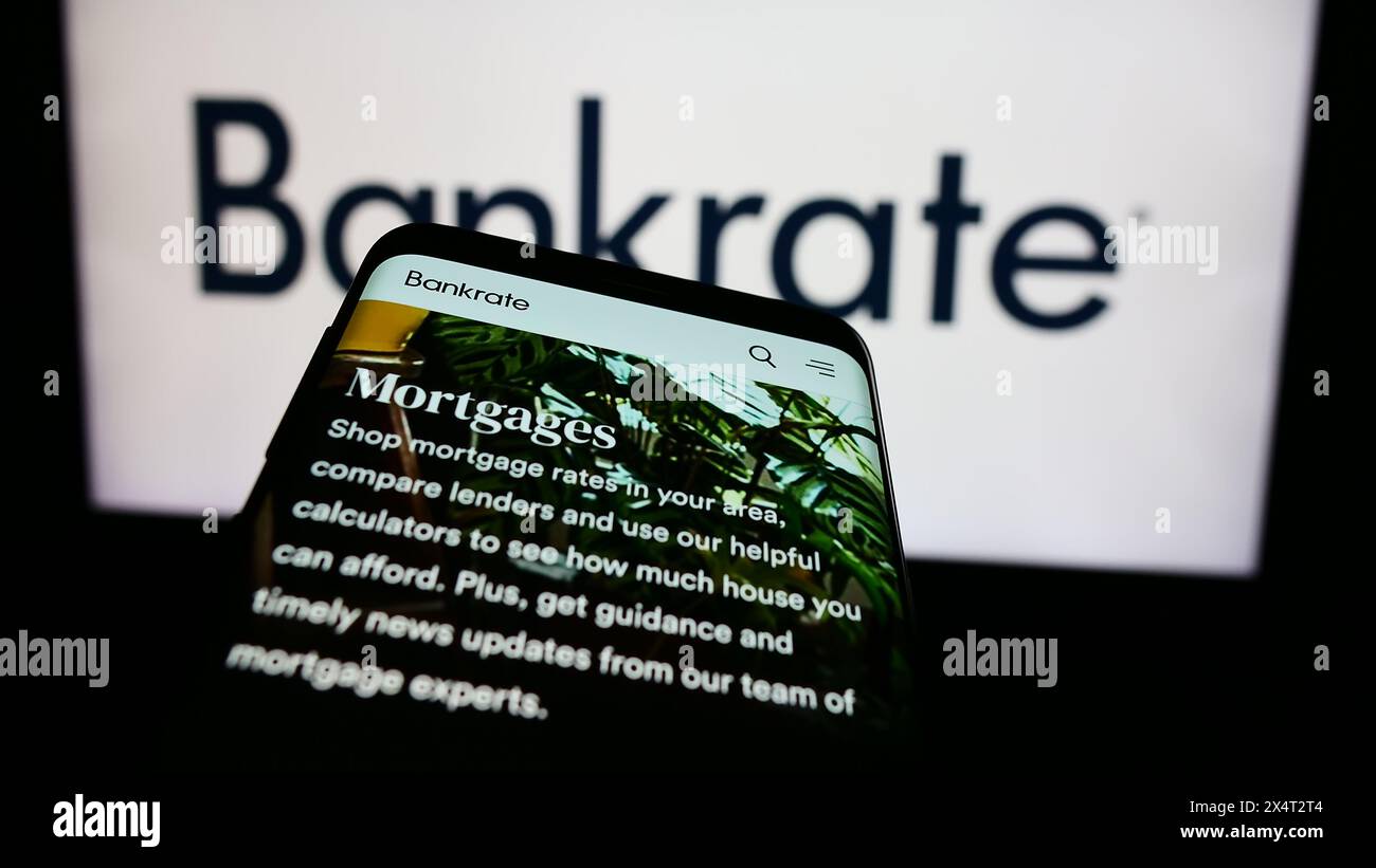 Mobiltelefon mit Website des US-amerikanischen Finanzunternehmens Bankrate LLC vor dem Geschäftslogo. Fokussieren Sie sich oben links auf der Telefonanzeige. Stockfoto