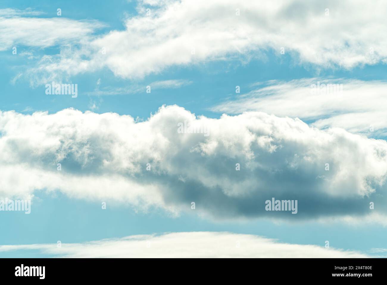 Ein azurblauer Himmel mit flauschigen weißen Cumulus-Wolken, eine natürliche Landschaft, die die Schönheit der Atmosphäre unterstreicht. Der elektrische blaue Horizont Compllet Stockfoto