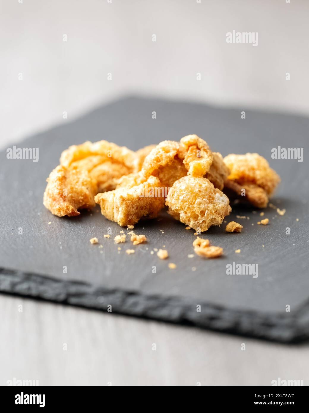 Snack mit gesalzenen Schweineschalen auf Schiefer Stockfoto