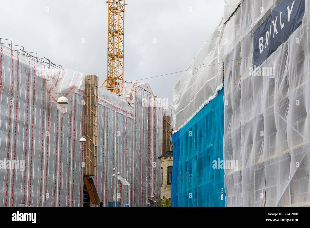 Göteborg, Schweden - 16. Oktober 2021: Gebäude mit Gerüsten und Windschutzabdeckungen. Gelber Kran im Hintergrund, keine sichtbaren Personen Stockfoto