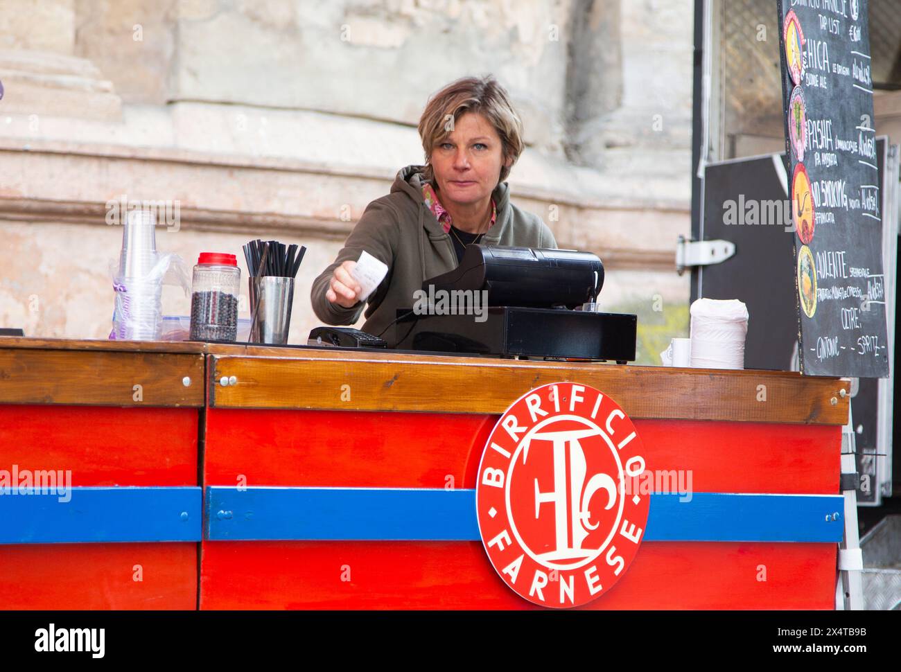 Frau an der Kasse, die Bier vom Fass verkauft Stockfoto