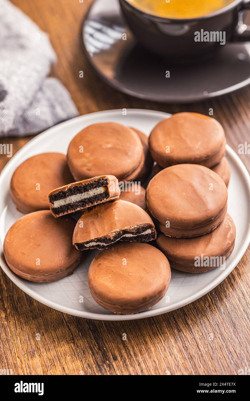 Nahaufnahme von schokoladenbeschichteten Sandwichkeksen auf einem Holztisch. Stockfoto