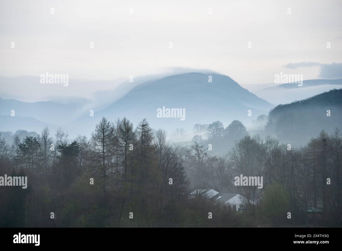 Wunderschönes Landschaftsbild des nebeligen Frühlingsvormittags im Lake District mit Blick auf entfernte nebelige Gipfel Stockfoto