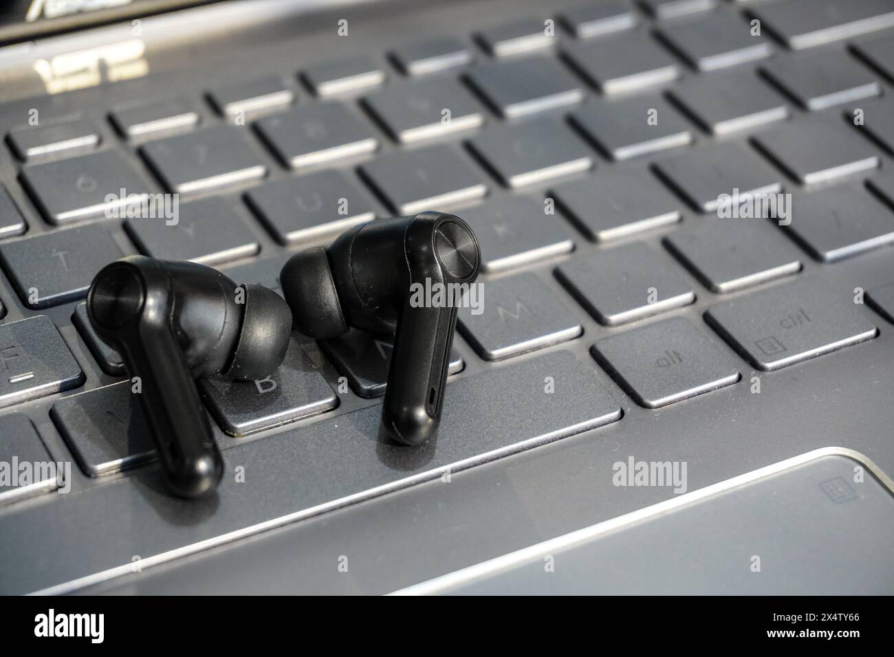 Schwarze schnurlose Ohrhörer auf der Laptop-Tastatur Stockfoto