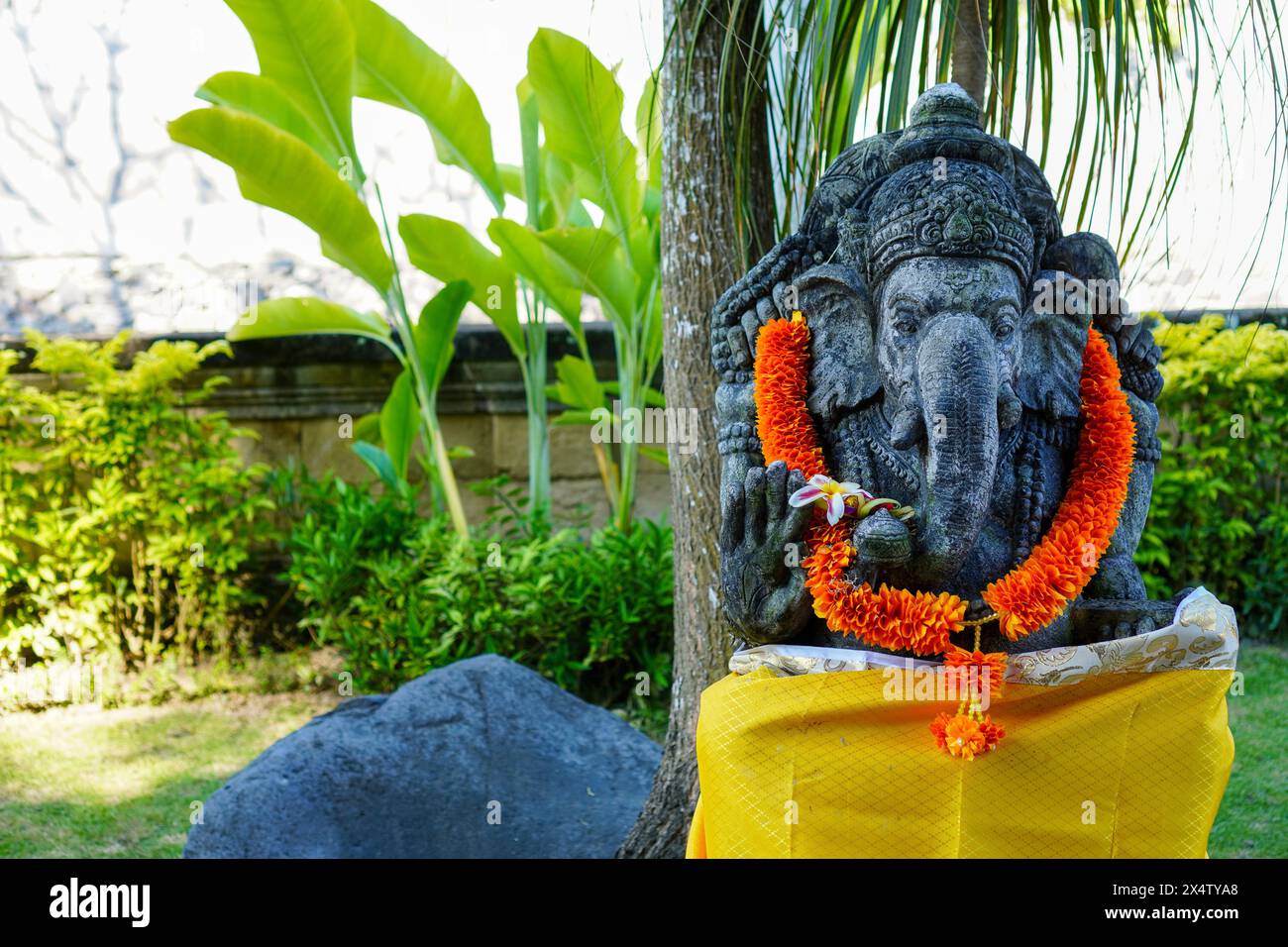 Statue von Lord Ganesha mit einer gelben Girlande, eine Tradition der religiösen Hindubali Stockfoto