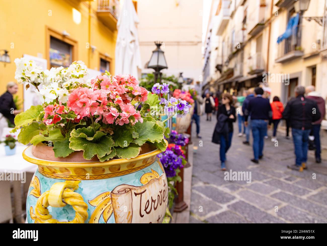 Sorrent Straßenszene im Frühling mit Menschen, bunten Blumen und gepflasterten Straßen; Sorrent Italien. Italien reisen. Stockfoto