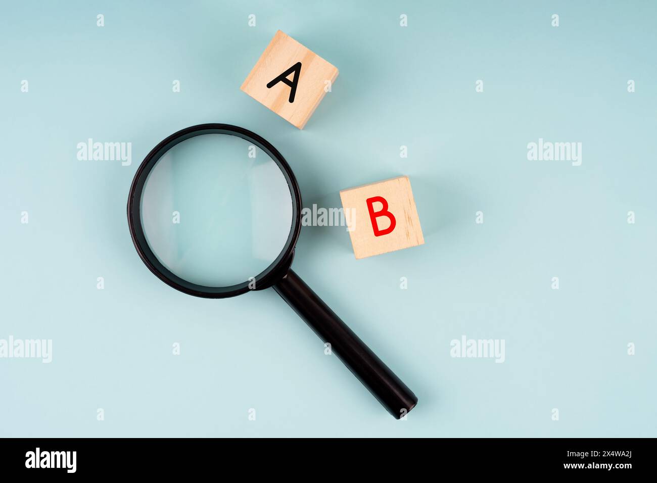 Lupe und Buchstaben A und B auf weichem blauem Hintergrund Stockfoto