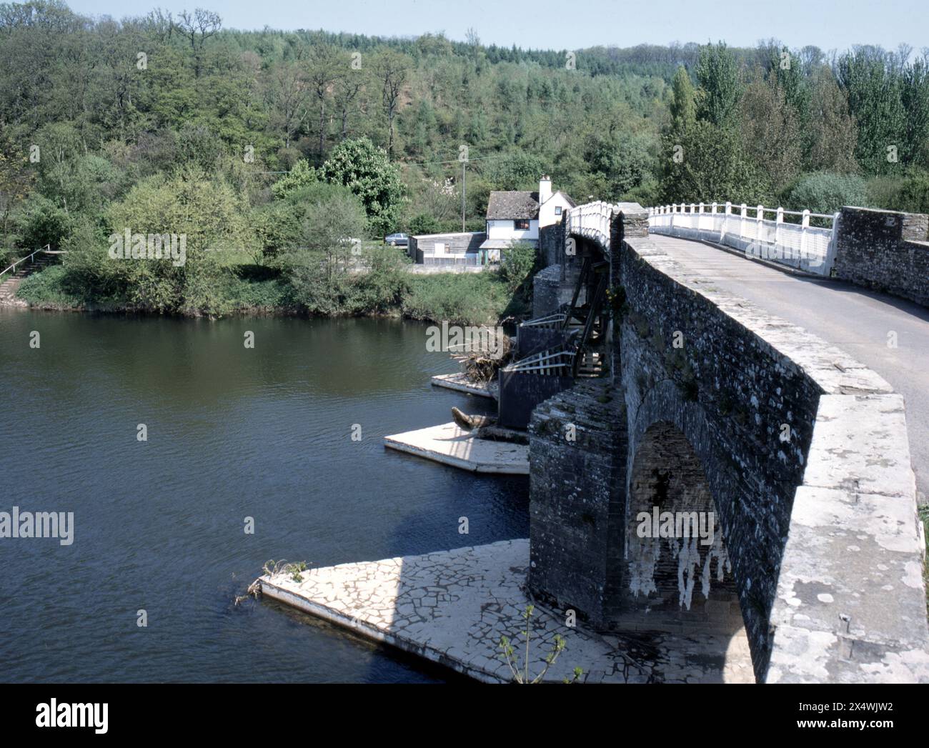 Die Whitney-on-Wye-Mautbrücke ist eine einspurige Holz- und Steinbauweise, die den Fluss Wye überquert und aus zwei denkmalgeschützten Bauwerken besteht Stockfoto