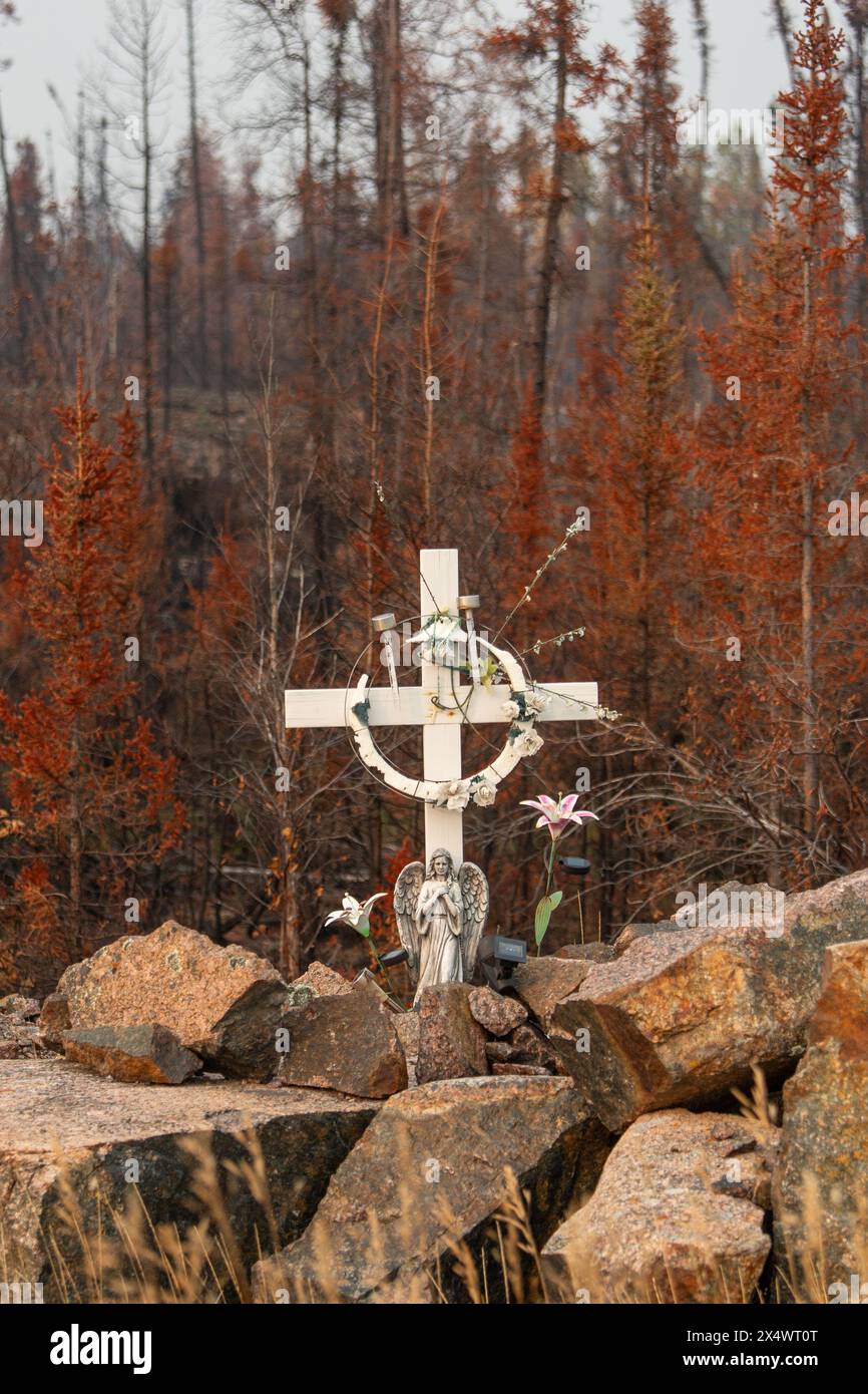 Kreuzmarker und Engel Figur entlang des Highway 3 außerhalb von Yellowknife, mit verbranntem Wald im Hintergrund, Northwest Territories, Kanada. Stockfoto