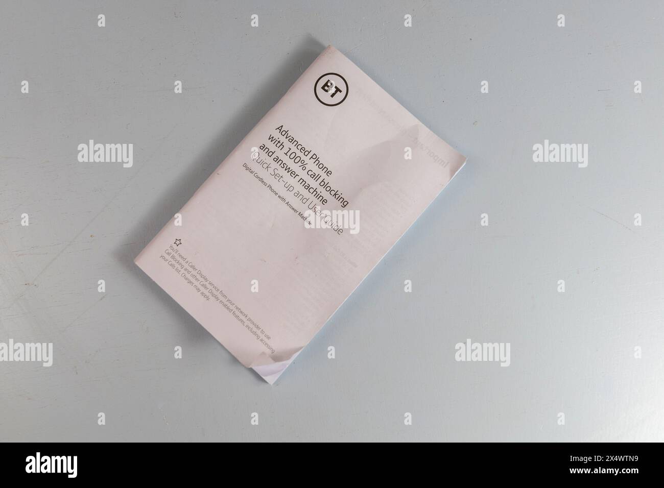 Benutzerhandbuch oder ein schnurloses analoges BT-Telefonsystem mit Anrufsperre, Anrufbeantworter auf einem hellblauen Tisch Stockfoto