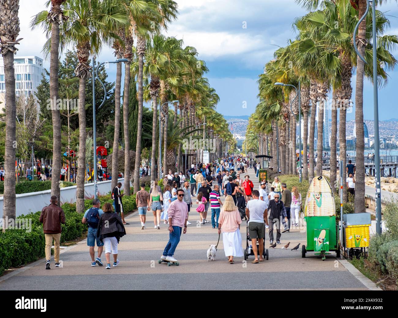 Menschenmassen laufen entlang der palmengesäumten Promenade, Limassol, Zypern Stockfoto