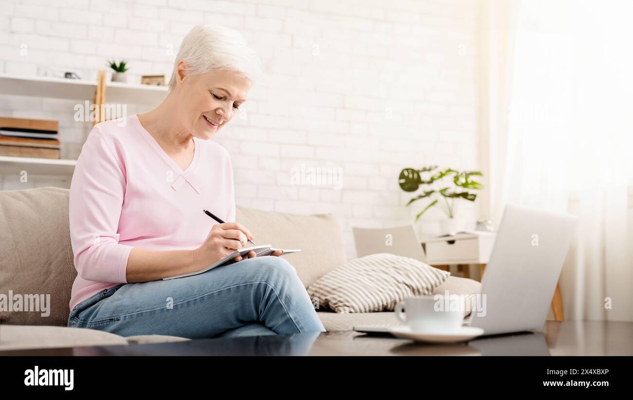 Ältere Frau schreiben sie Gedanken und Arbeiten am Laptop Stockfoto