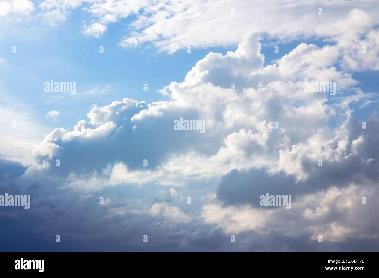 Wolken am blauen Himmel im Nachmittagslicht. Stürmisches Wetter nähert sich im Sommer Stockfoto