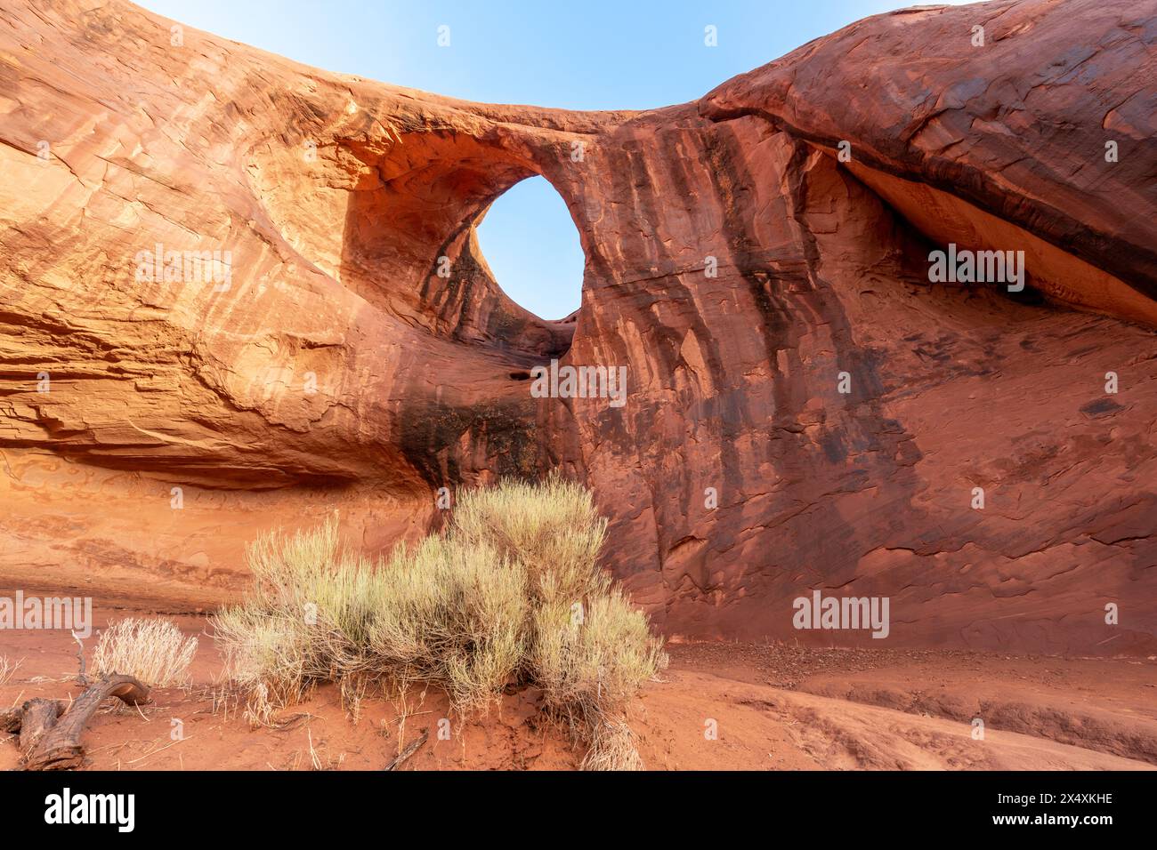 Eye of the Sun Arch im Monument Valley zeigt die Wasser- und Windeffekte der Erosion über Millionen von Jahren. Stockfoto