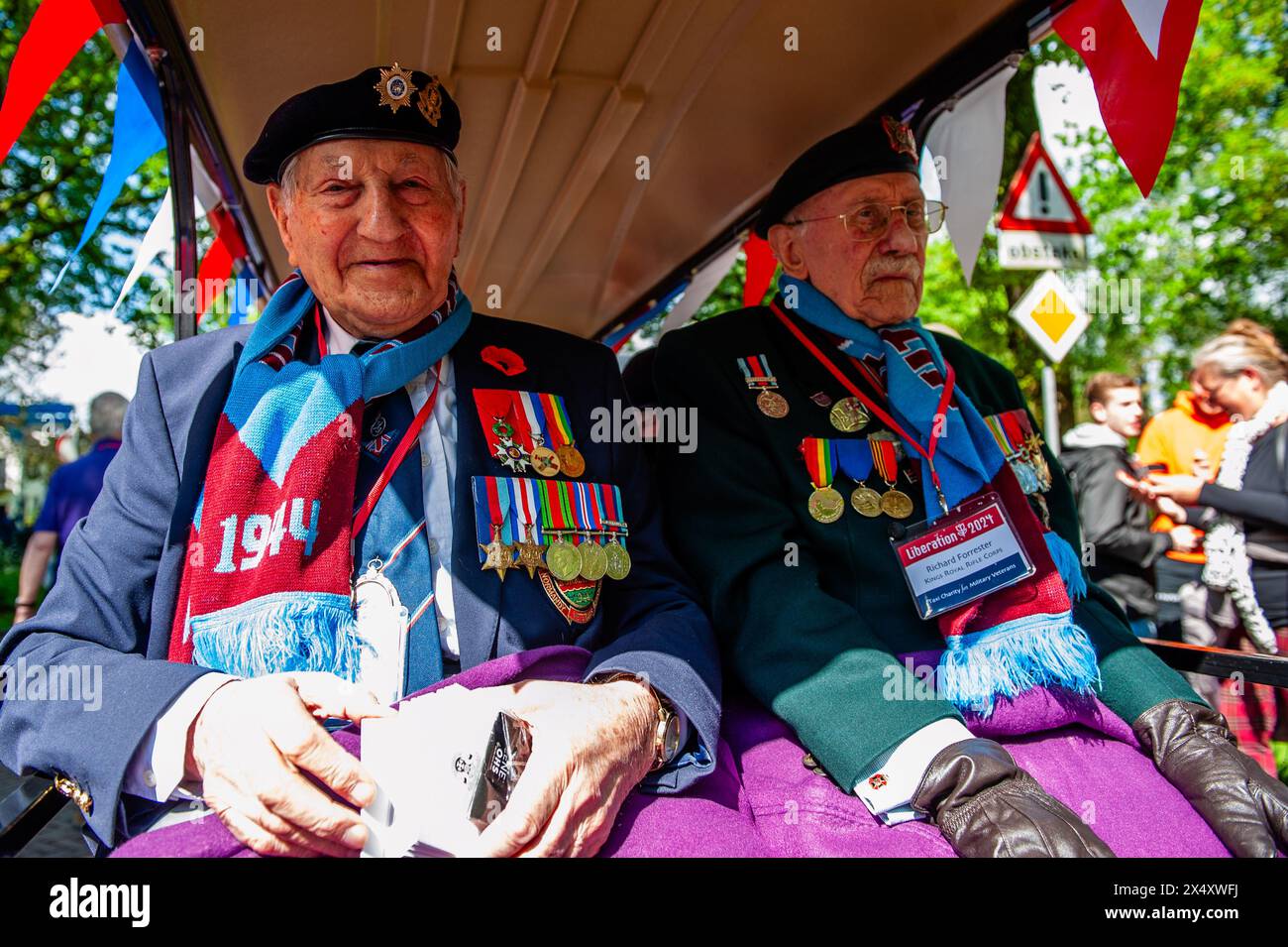 Wageningen, Niederlande. Mai 2024. Zwei Veteranen des Zweiten Weltkriegs werden während der Parade beim Lächeln des Publikums beobachtet. Während des Befreiungstages findet die Befreiungsparade (Bevrijdingsdefilé) statt, die Veteranen und militärische Nachfolger zusammenführt, um all jenen zu würdigen, die während des Zweiten Weltkriegs ihr Leben gaben, und der internationalen militärischen Zusammenarbeit. An der Front der Parade standen zwölf britische Veteranen, die im Zweiten Weltkrieg für die Freiheit der Niederlande kämpften. (Foto: Ana Fernandez/SOPA Images/SIPA USA) Credit: SIPA USA/Alamy Live News Stockfoto