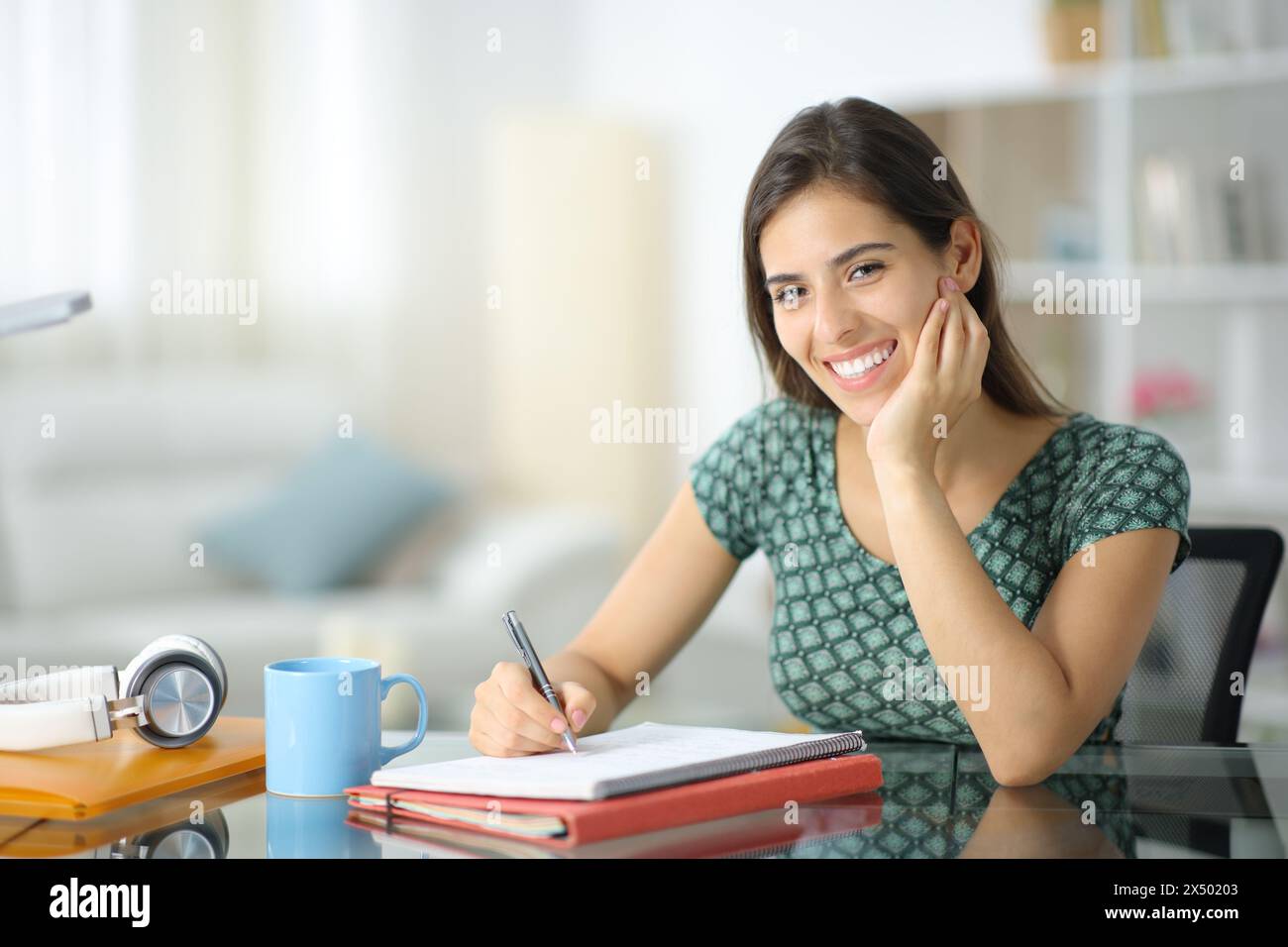 Porträt eines glücklichen Schülers, der zu Hause posiert und dich ansieht Stockfoto