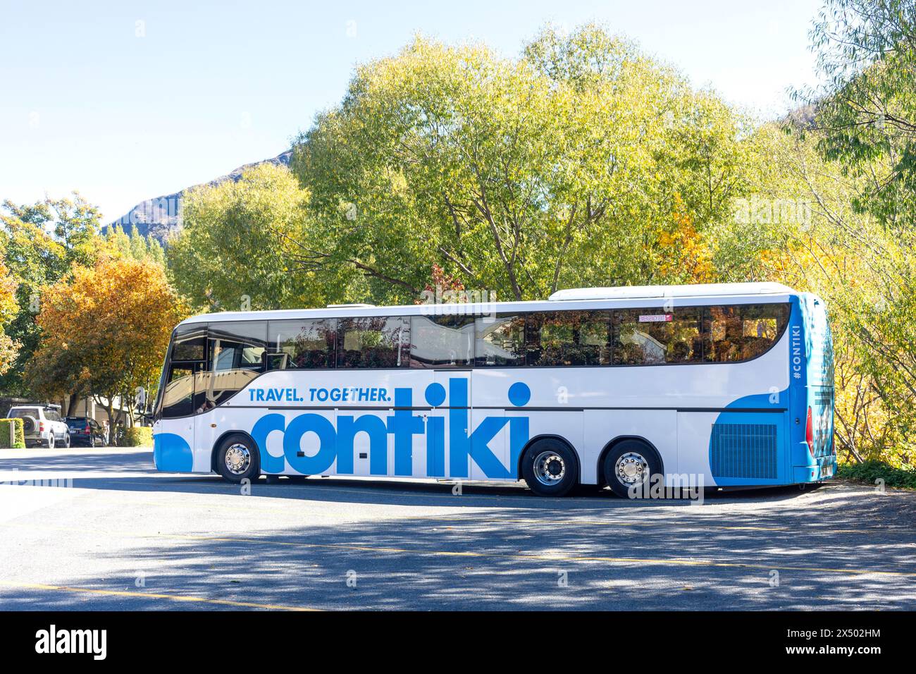 Contiki Travel Tour Bus parkt in Ramshaw Lane, Arrowtown, Otago, Südinsel, Neuseeland Stockfoto