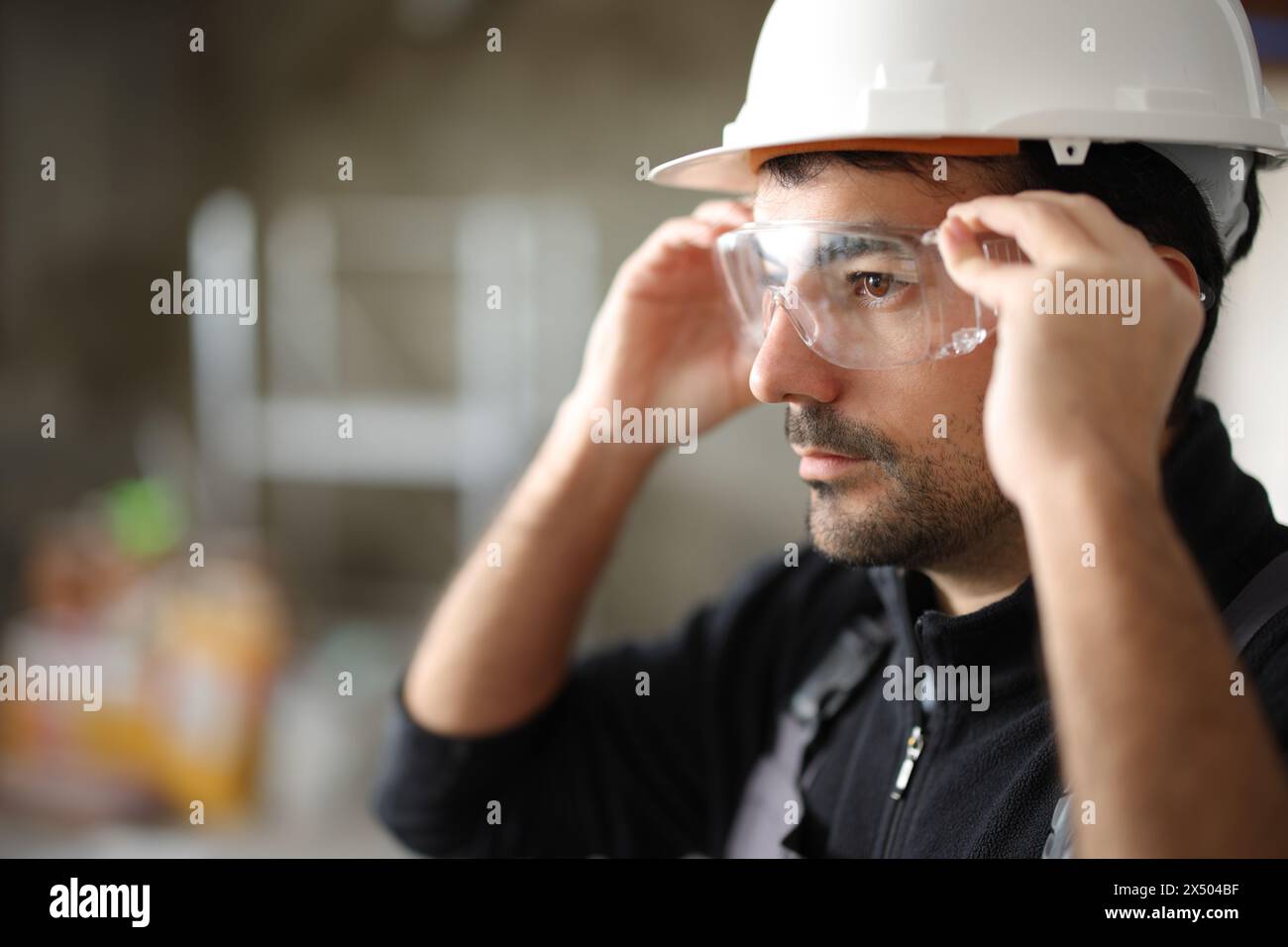 Bauarbeiter, der eine Schutzbrille in ein renoviertes Haus bringt Stockfoto