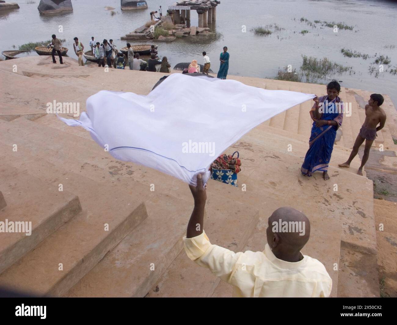 Hindus Pilger zum Tempel in Hampi trocknen Stoffe im Wind, nachdem sie sie gewaschen haben. Stockfoto