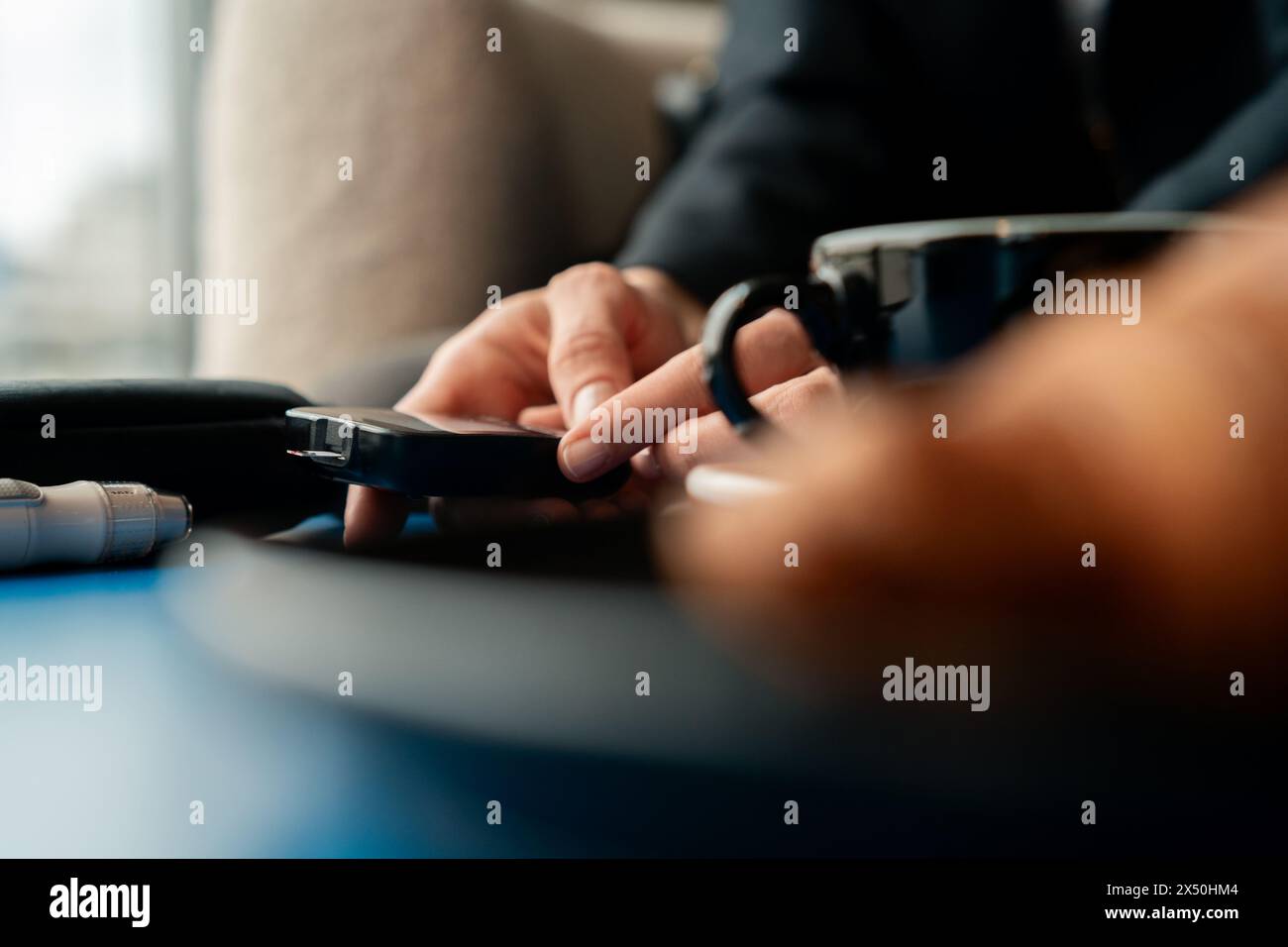 Nahaufnahme einer Frau, die den Blutzuckerspiegel in einem Café überprüft, bevor sie einen Matcha-Tee trinkt Stockfoto