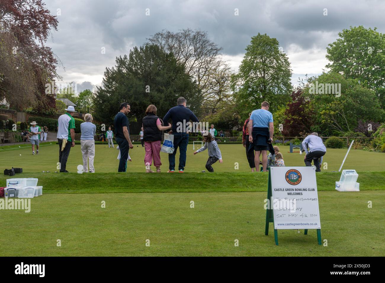 Leute Familien versuchen Rasenbowlen am Castle Green Bowling Club Tag der offenen Tür, Guildford, Surrey, England, Vereinigtes Königreich, im Mai 2024 Stockfoto