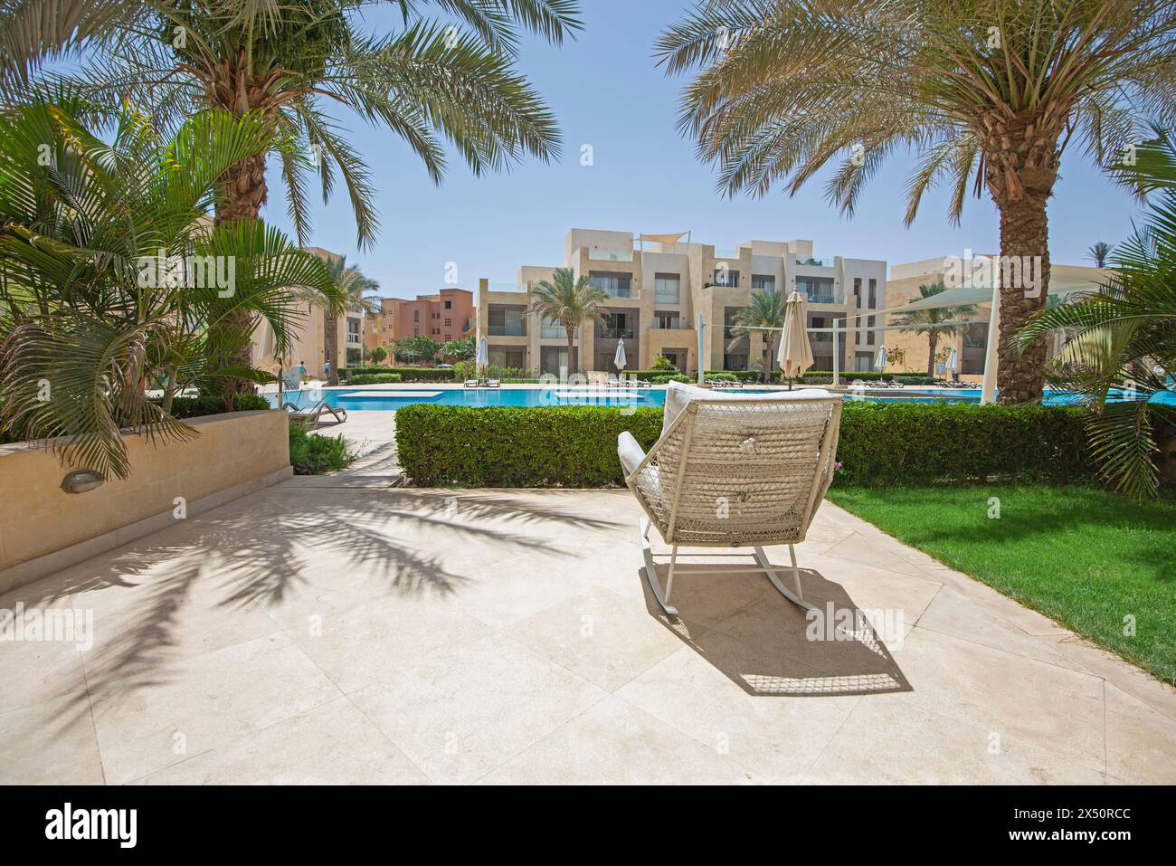 Gartenterrasse eines luxuriösen Apartments in tropischem Resort mit Möbeln und Blick auf den Swimmingpool Stockfoto