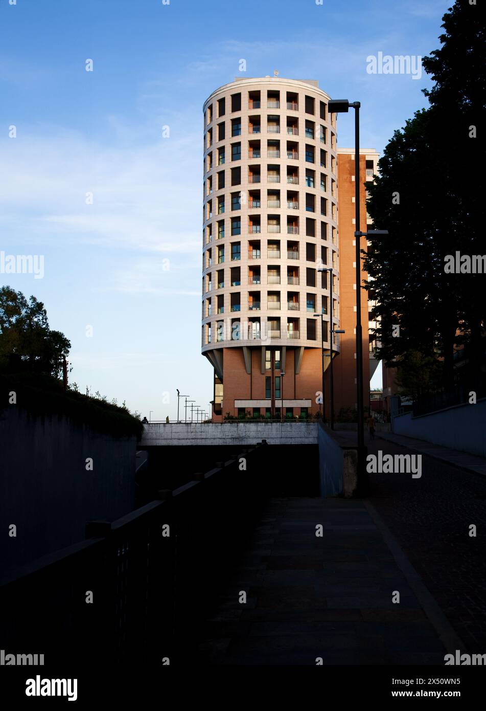 Modernes zylindrisches Gebäude, das bei Sonnenuntergang gefangen gehalten wird Stockfoto