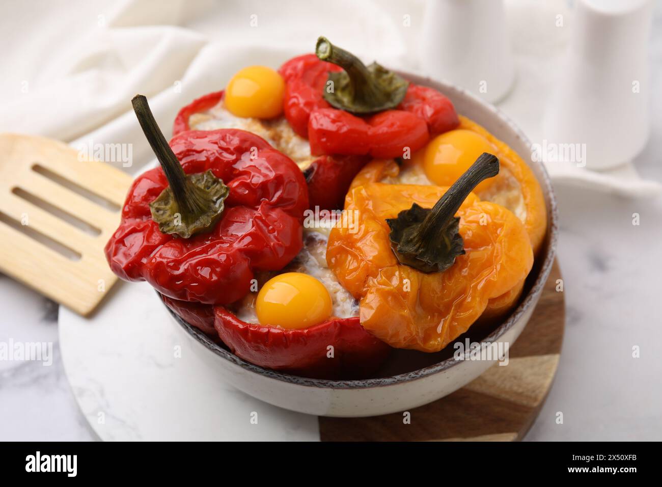 Köstliche gefüllte Paprika mit Spiegeleiern auf weißem Marmortisch Stockfoto