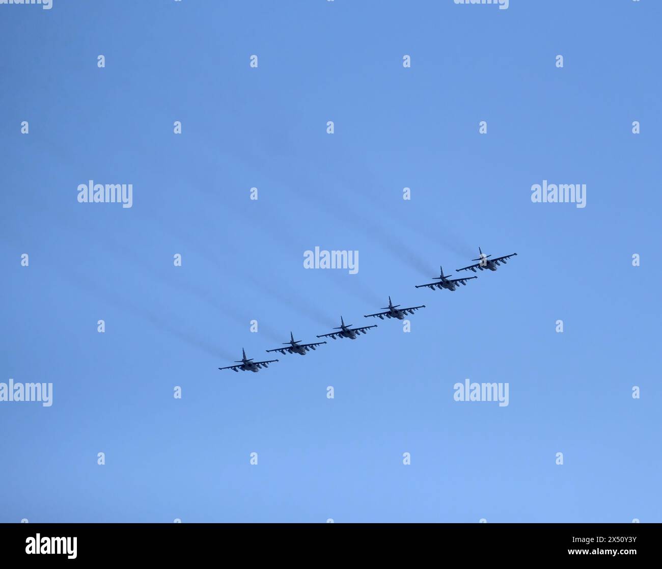 Kampfjet-Formation von sechs russischen militärischen taktischen Frontlinienbombern SU-25 Frogfoot, die schnell im wolkenlosen blauen Himmel fliegen Stockfoto