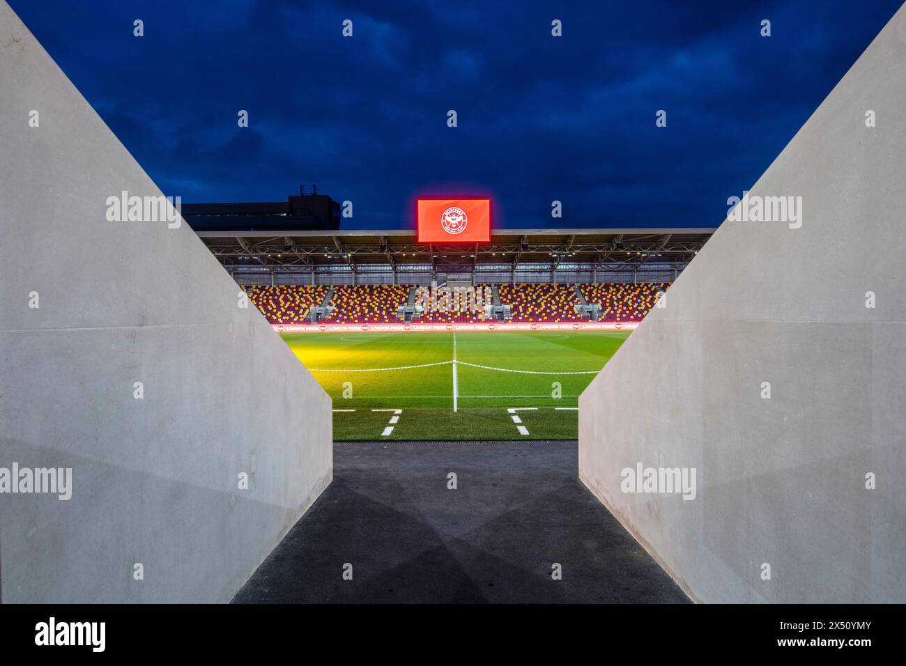 Blick in die Dämmerung über das Spielfeld vom Spielertunnel aus. Brentford Community Stadium, Brentford, Vereinigtes Königreich. Architekt: AFL Architects, 2020. Stockfoto