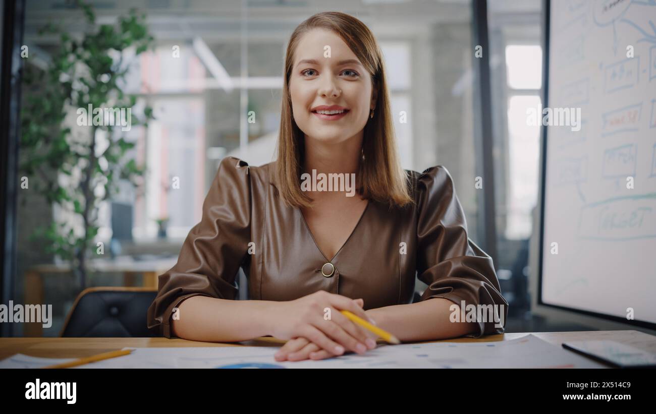 Blickwinkel aus der Kamera mit dem schönen jungen Projektmanager, der ein Videogespräch in einer kreativen Büroumgebung führt. Glückliche kaukasische Spezialistin, die Kollegen über eine Live-Kamera zuhört. Stockfoto