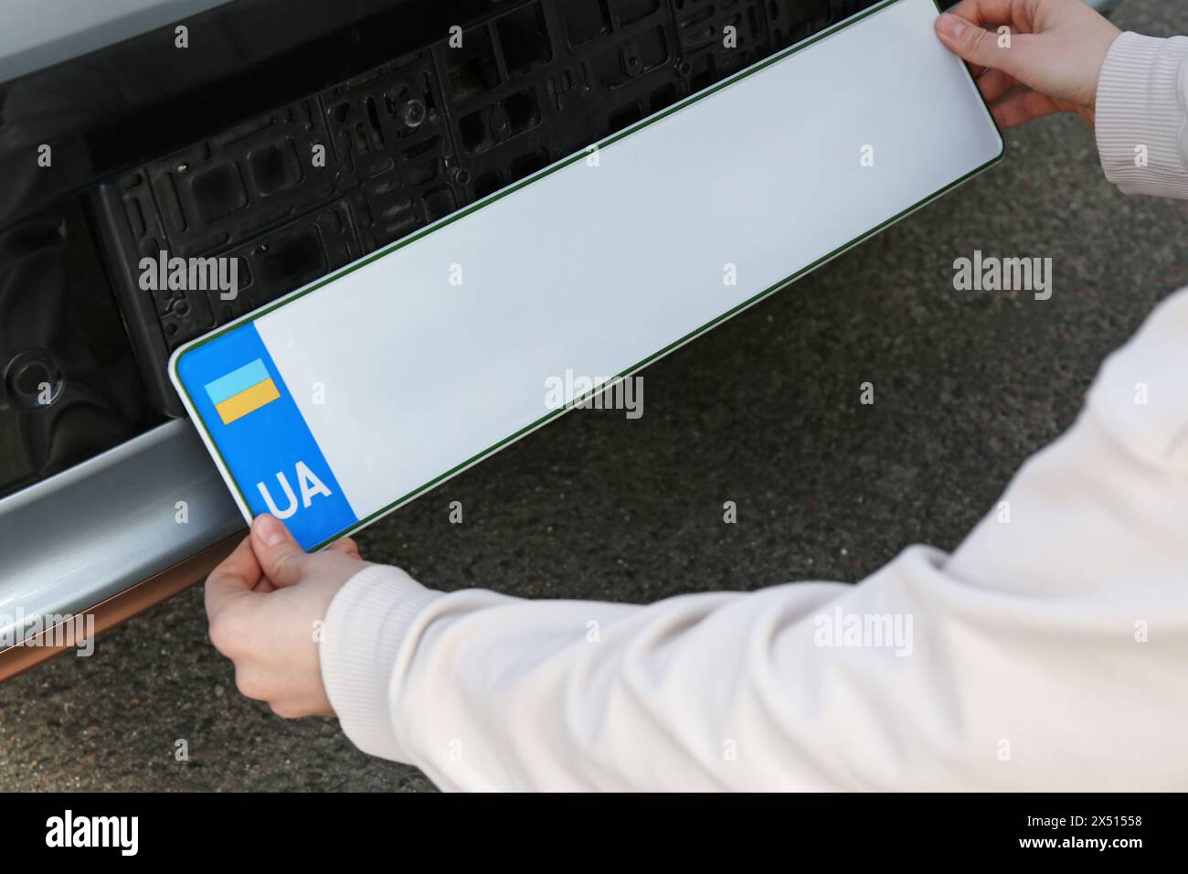 Frau, die das Kennzeichen draußen anbringt, Nahaufnahme Stockfoto