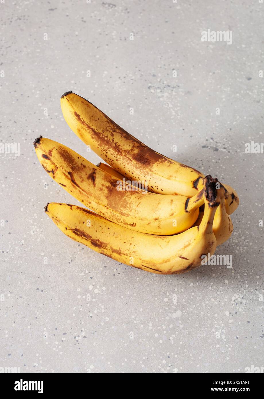 Reife überreife Bio-Bananen auf konkretem Hintergrund. Hässliche Lebensmittel Null Abfall Konzept Stockfoto