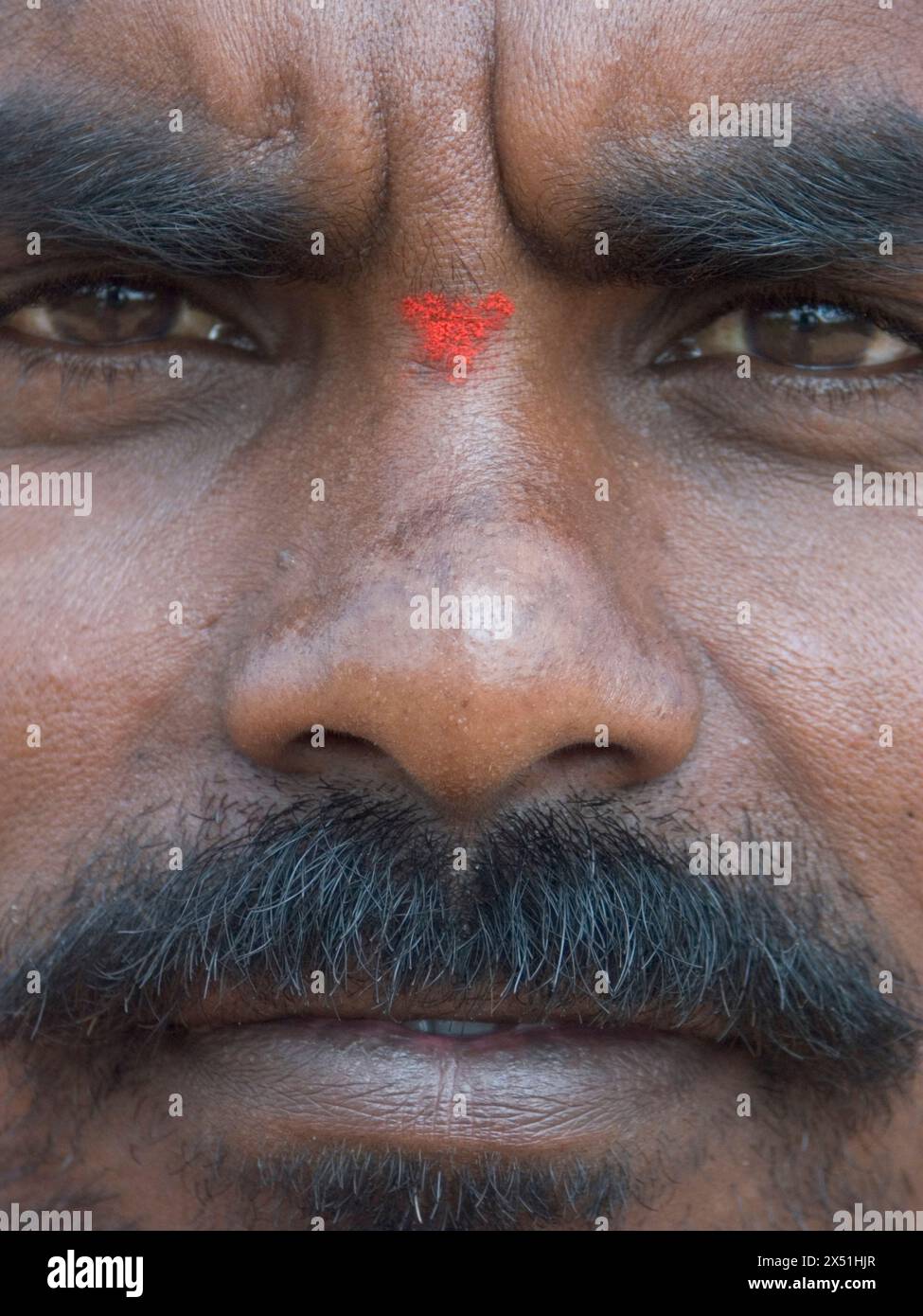 Ein Hindu-Pilger, der sich mit dem farbigen Pulver markiert hat, das in Gebetsritualen verwendet wird, um zu zeigen, dass er seine Morgengebete außerhalb des Hindu-tempels getan hat Stockfoto
