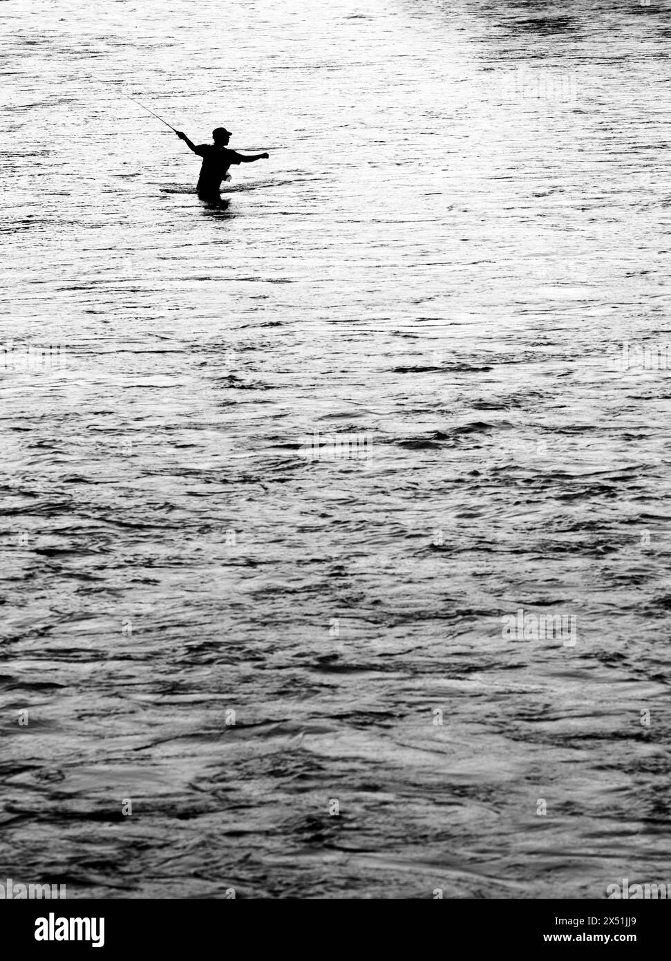 Ein Fliegenfischer wirft über einen Fluss Stockfoto