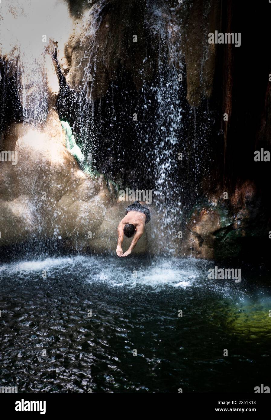 Man taucht durch einen Wasserfall in der Finca Paraiso, Guatemala Stockfoto