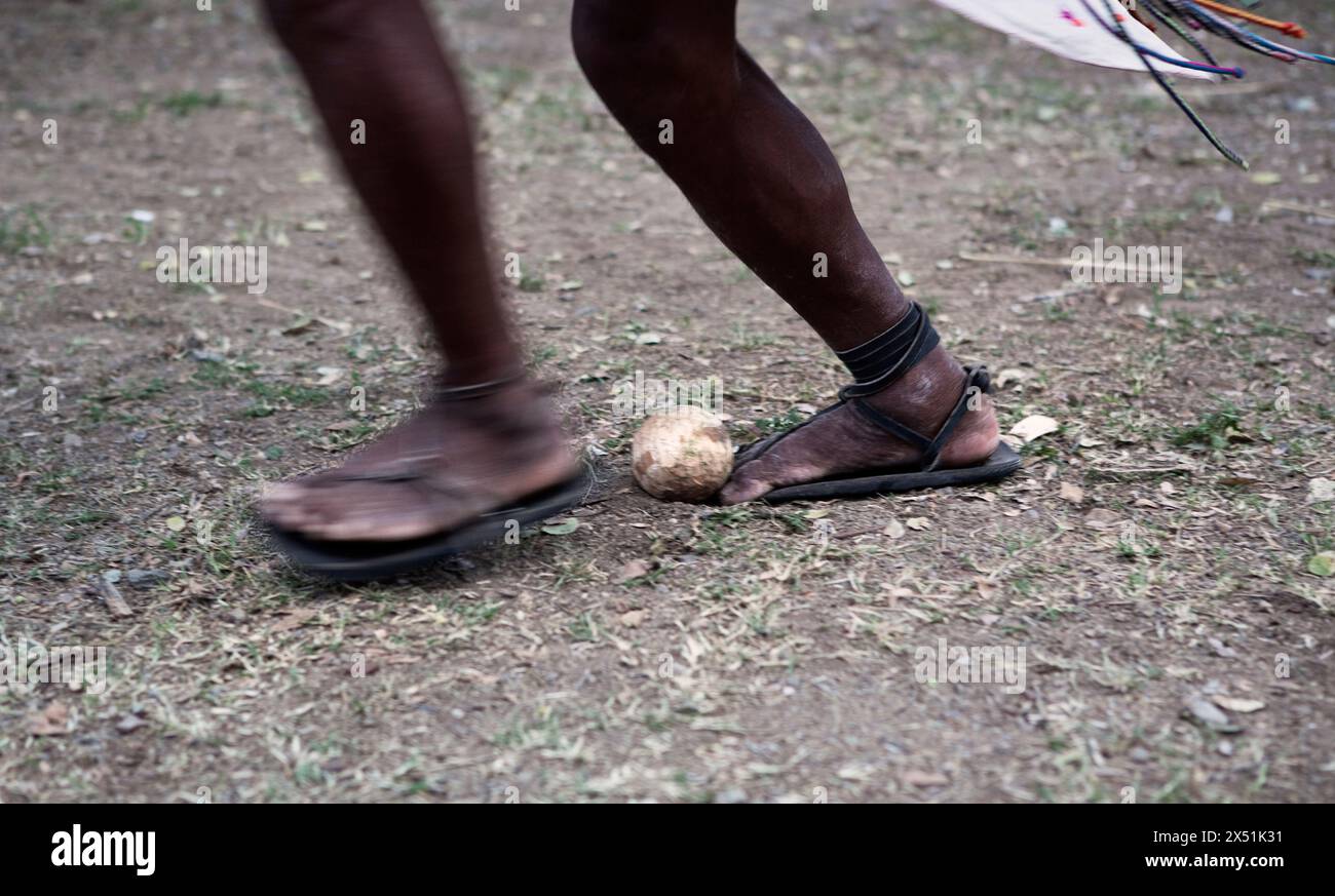 Ein Tarahumara-Indianer schleudert während eines Spiels Rarj'paro mit den Füßen eine Holzkugel. Stockfoto